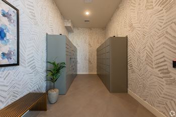 a mens locker room with two gray lockers and a potted plant at Aura Vegas Apartments, Las Vegas, NV